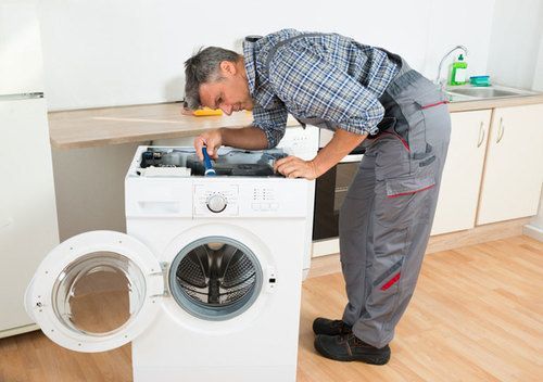 Мастер проводит диагностику поломки стиральной машины
